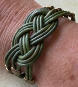 close-up of green leather bracelet woven in celtic knot pattern on wrist