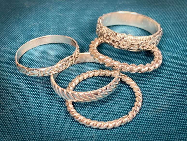 silver stacking rings laying on blue background