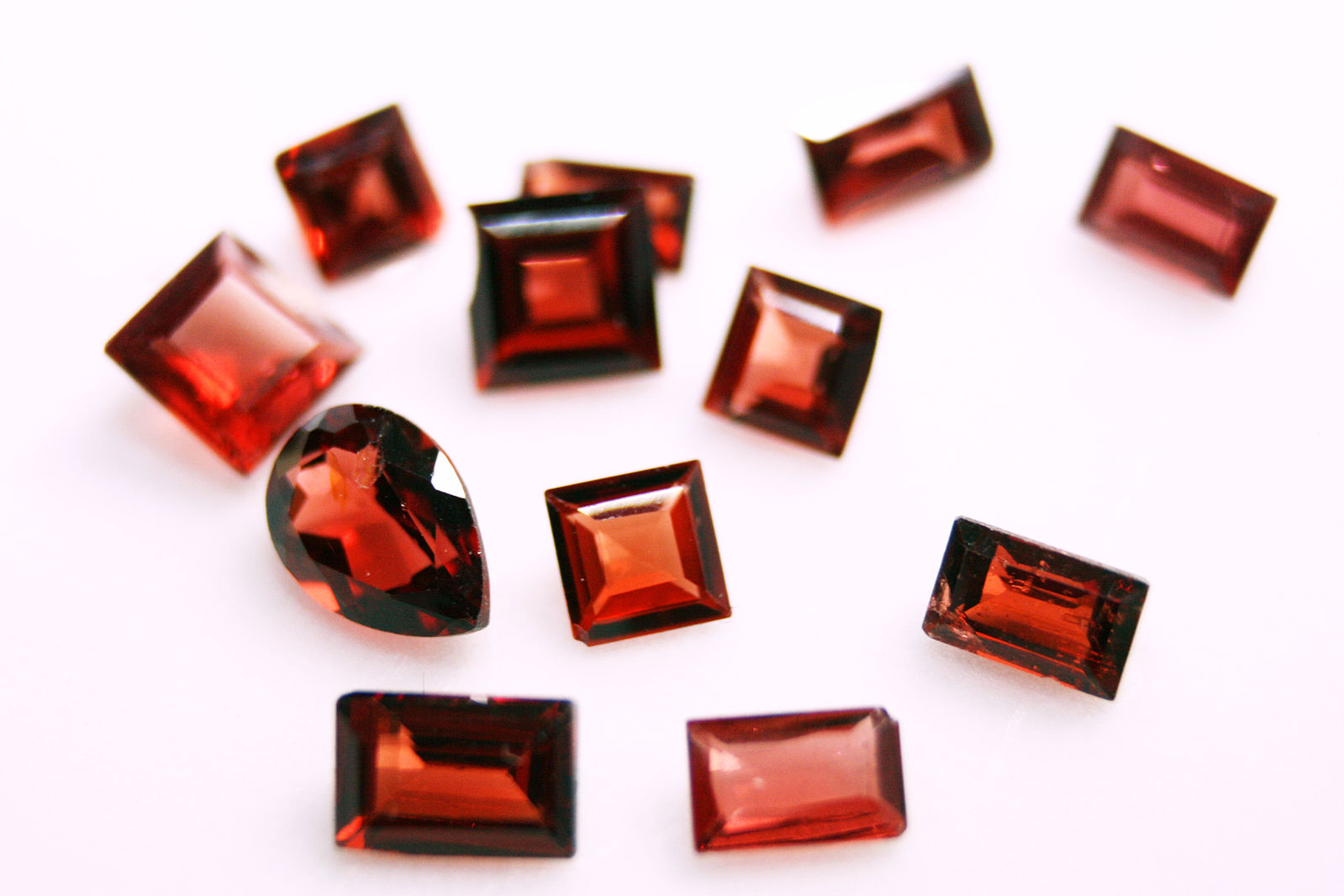 Cut_garnet_collection deep red garnet gemstones in princess, emerald and teardrop cuts
