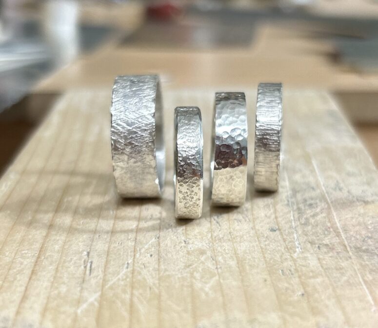 Four wide band silver rings with various textures